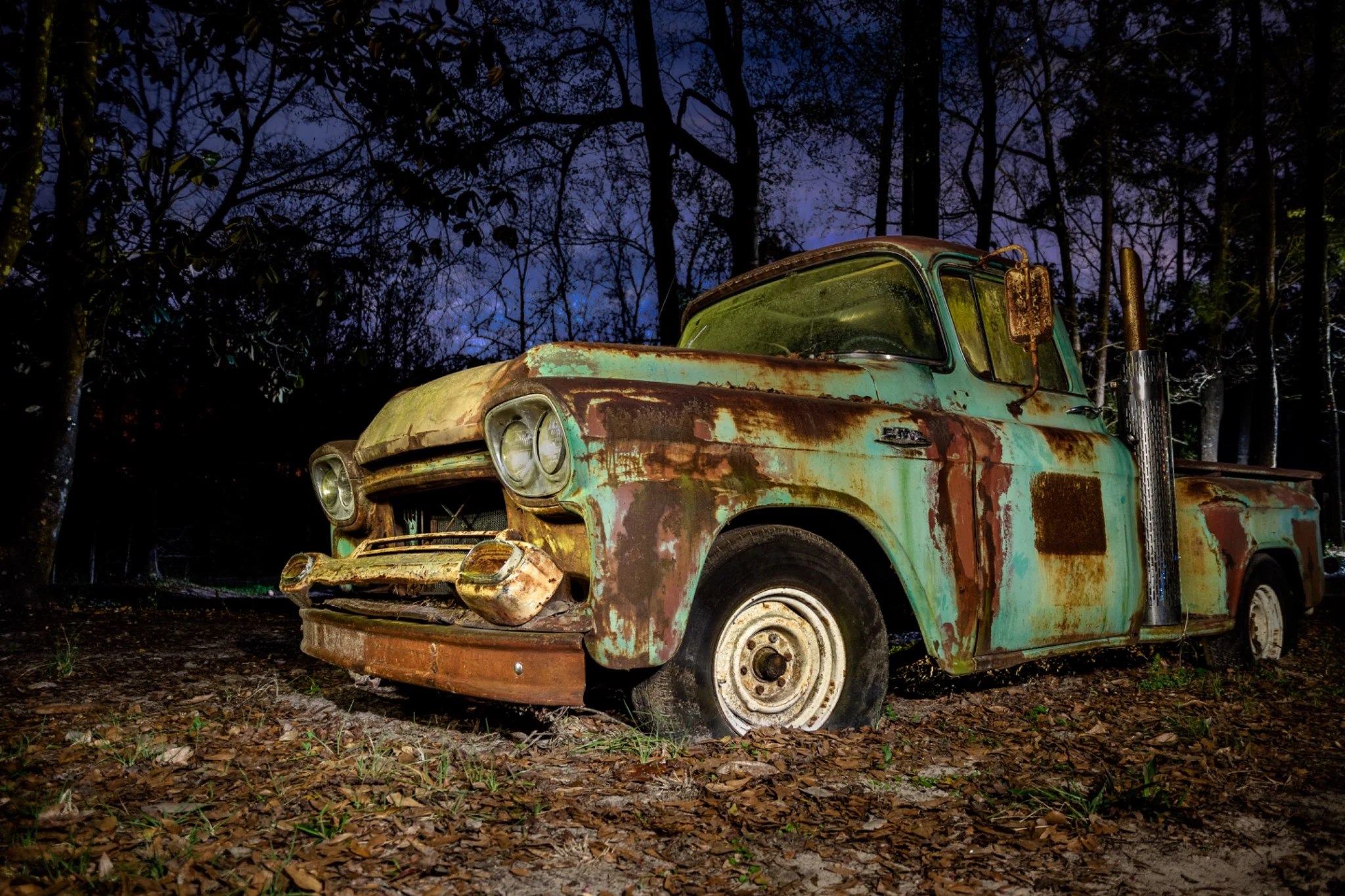 A weathered vintage truck resting in a rural landscape